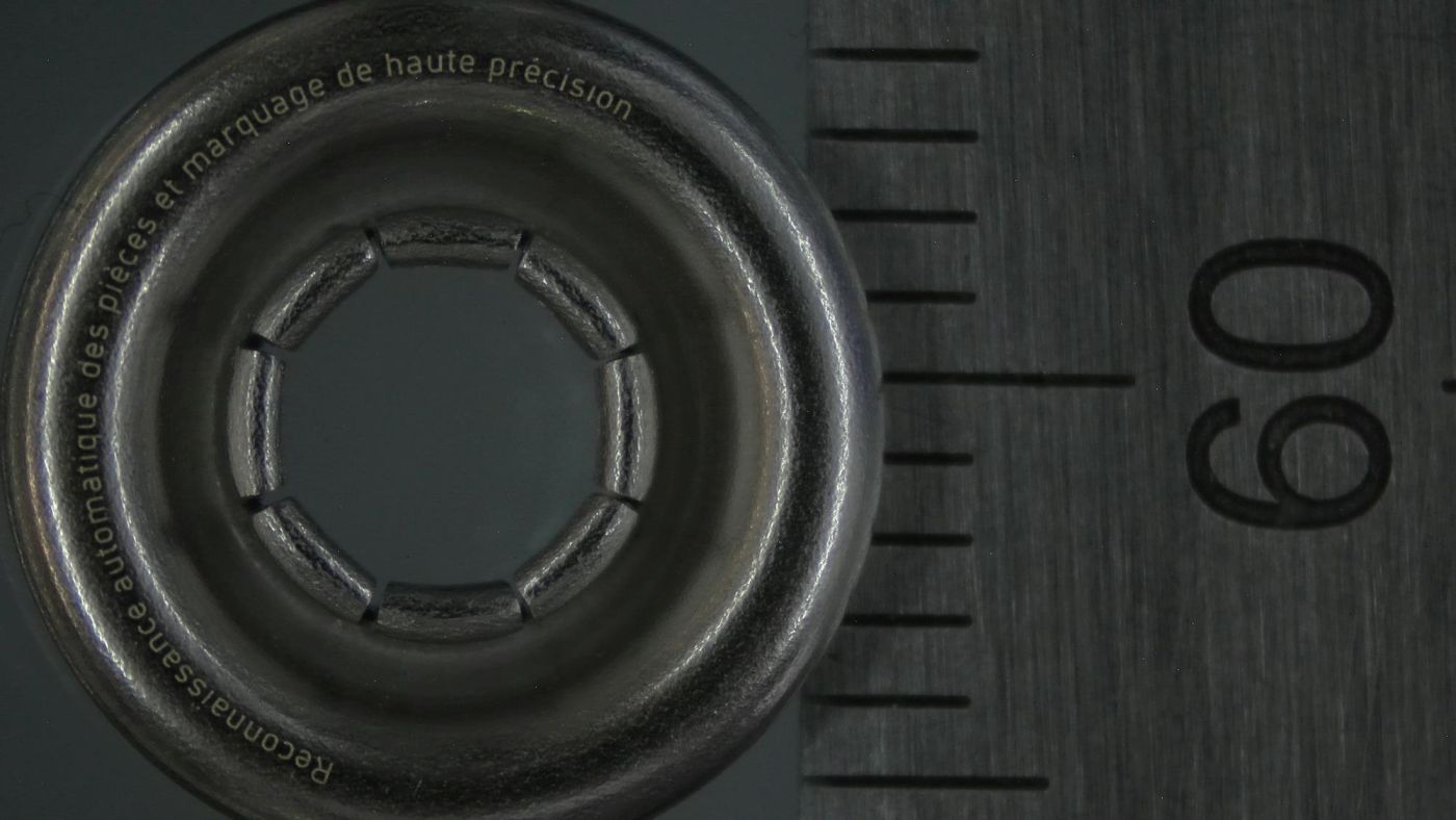 Filigrane Laserbeschriftung einer Metallöse von 11mm Durchmesser