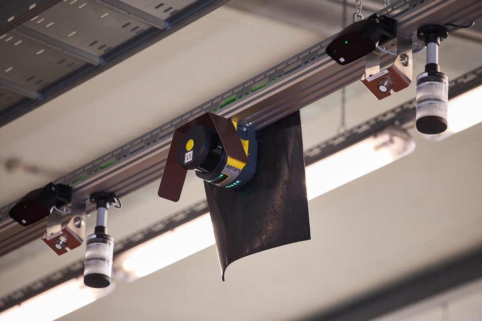 Blick auf die Sicherheitstechnik im Übergabebereich: Ein Sicherheits-Laserscanner RSL 400 von Leuze